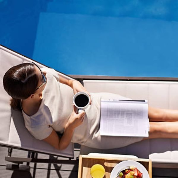 Top view of an attractive young woman enjoying her breakfast by the pool